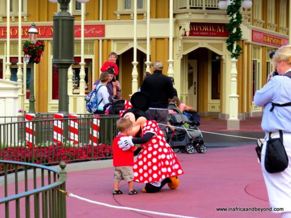 Minnie Mouse embraces a toddler