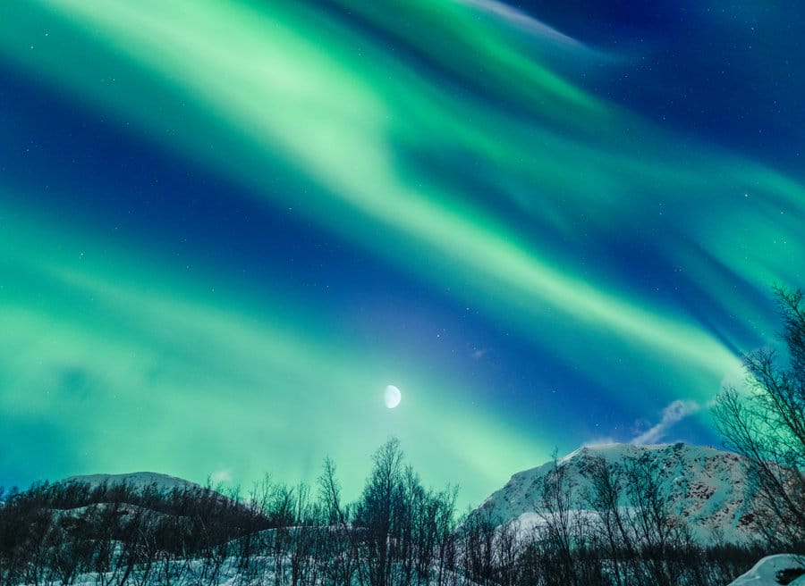 best destinations in finland - A beautiful view of a night winter landscape with Aurora borealis and the moon,Tromso